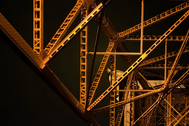 Orange-lit steel girders against the night sky