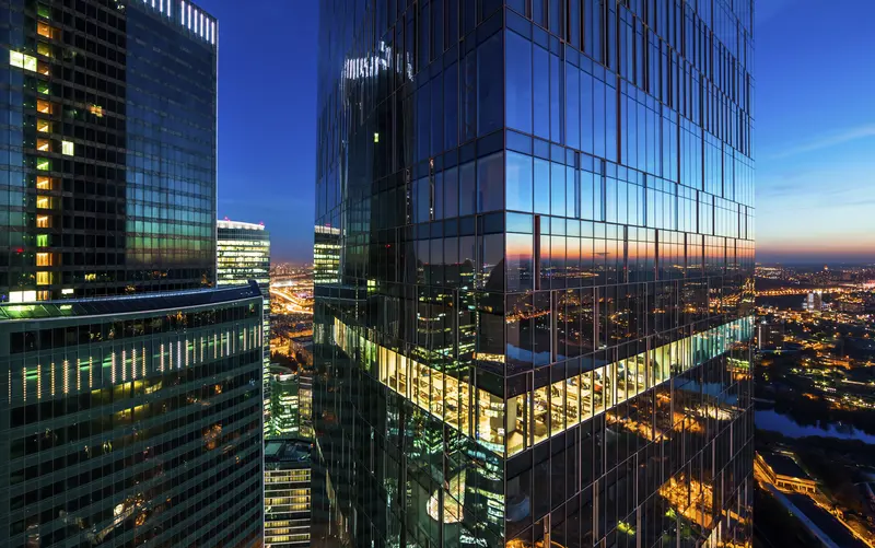 Glass towers lit at nightfall